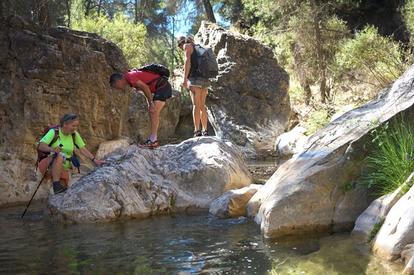 hikers avoid some deep rock pools by climbing some boulders