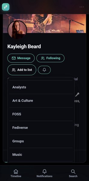 Mobile app view of Kayleigh Beard's profile with her name and profile picture showing at the top. Four action buttons are visible: Message, Following, Add to list, and notifications bell. The 'Add to list' menu is expanded, displaying six list categories: Analysts, Art & Culture, FOSS, Fediverse, Groups, and Music. At the bottom, three navigation icons show Timeline, Notifications, and Search tabs.