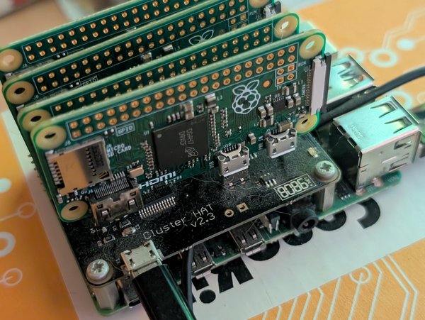 A Raspberry Pi with a hat that allows you to plug in four Raspberry Pi zeros via their USB data connection to run as a cluster.
