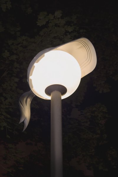 A Baseball cap on a round lamp.